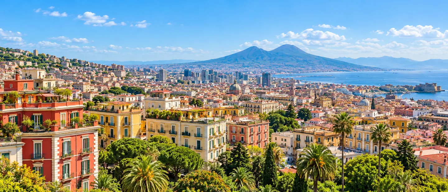 Napoli di giorno dall’alto: i palazzi colorati, le palme, il golfo e il Vesuvio sullo sfondo